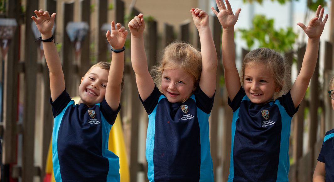 Nursery children playing with open arms.