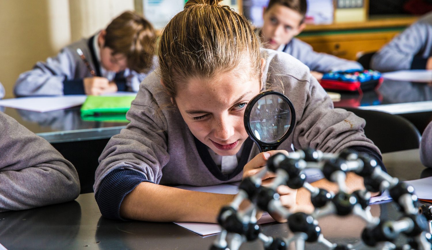 Student looking through magnifying glass