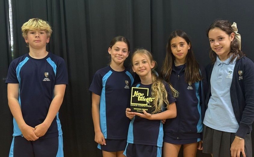 Four girls and a boy smiling with their award