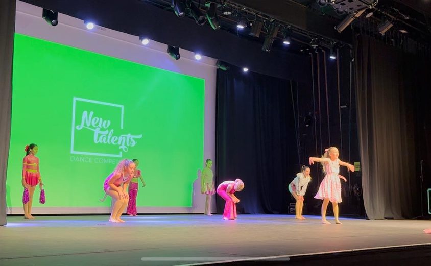 Group of girl dancers in pink performing on stage