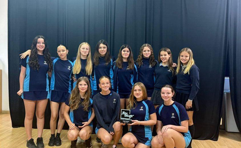 Large group of dancers posing with their award in sports clothes