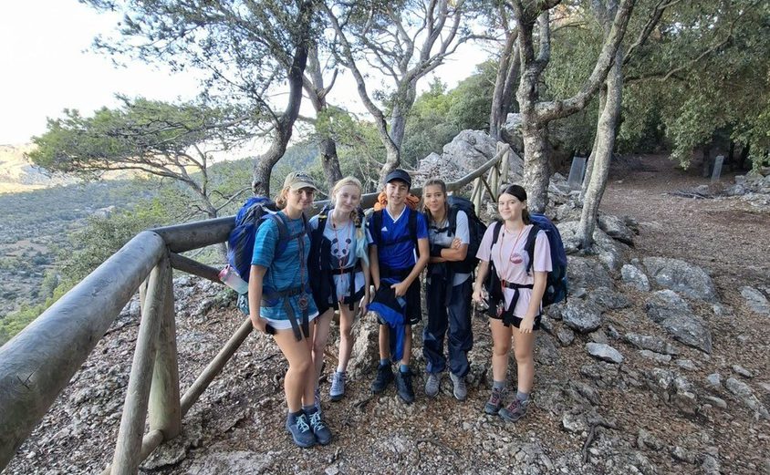 Dof E Five students standing in front of fence on rocky pathway