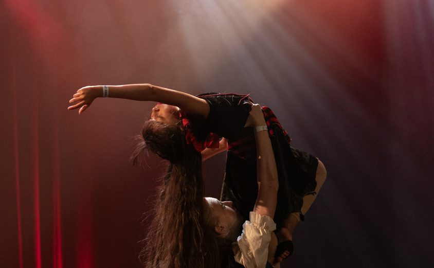 Pirate dance one girl being lifted above her head with arched back