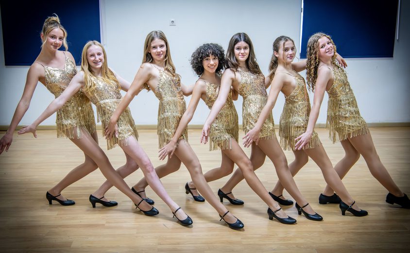 Dance girls in gold flapper dresses in pose