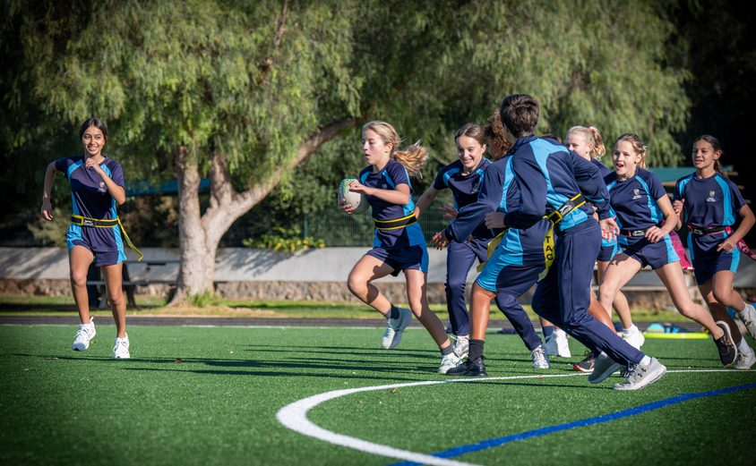Secondary students playing touch rugby on the Astro Turf
