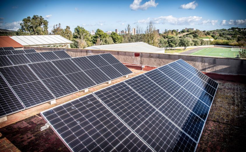 Solar panels on roof with part of Astro Turf in background