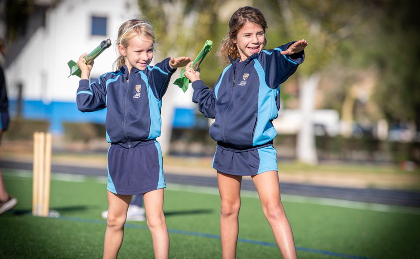 Two primary girls throwing a junior javelin on the Astro Turf