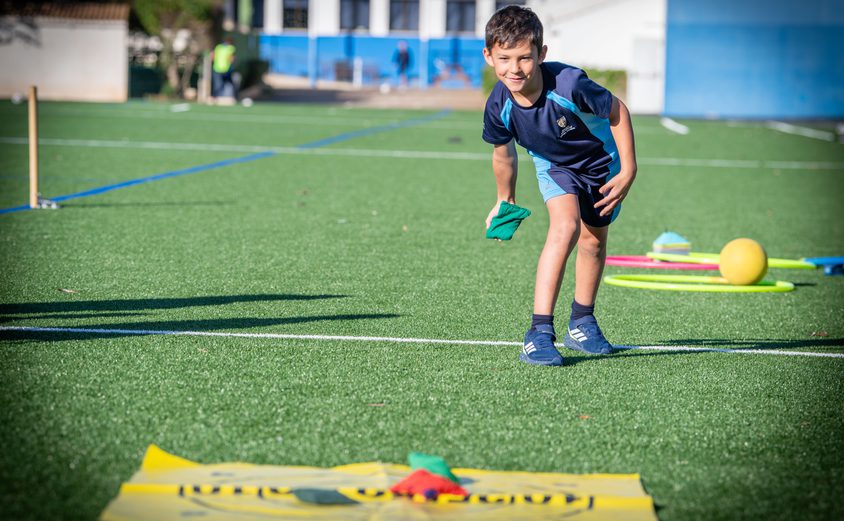 Year 4 boy on the Astro Turf throwing a beanbag onto a target